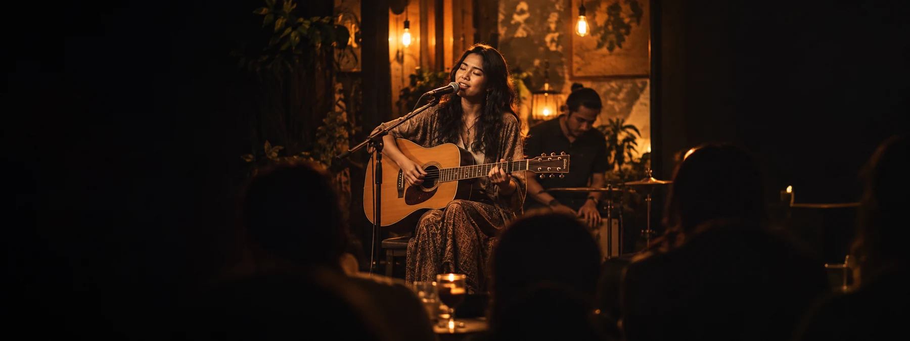 Penyanyi dengan gitar akustik di panggung kafe dalam cahaya amber